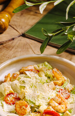 Fresh shrimp salad served on a wooden table with green decor