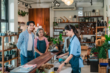 Asian Mother and Daughter Assist Male Customer at Ceramic Shop