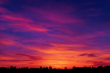 Vivid orange and purple sky over tranquil horizon during sunset, creating a stunning natural display perfect for desktop backgrounds