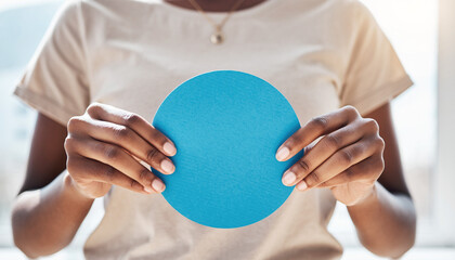 Close up of a woman's hands holding a blank blue circle for custom text or logo design