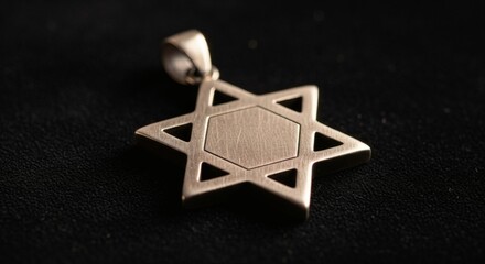 Close-up of a silver Star of David pendant on a dark background.