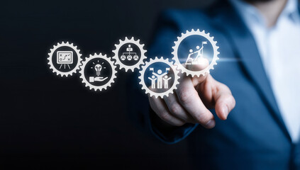 Businessman touching virtual cogwheels representing a business process workflow, including strategy, innovation, organization, and achieving goals.