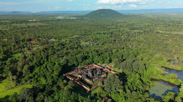 A pull-back ascending drone shot reveals Banteay Samre Temple surrounded by dense forest and wetlands in the Siem Reap