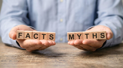 Hands holding wooden blocks labeled facts and myths, symbolizing the contrast between truth and misinformation in a thoughtful discussion