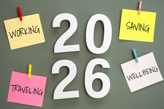 4 post-it paper clip on a green board with number 2026 in the middle and word working, saving, traveling, wellbeing around. new year goal target for work life balance concept
