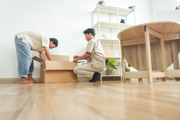 Team Moving House Unpacking Belongings in New Home With Excitement