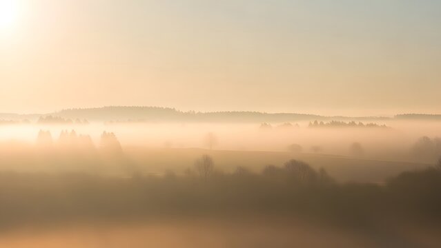 Misty golden sunrise over a distant mountain range in a hazy landscape