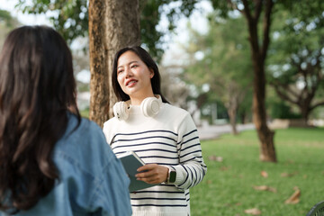 Young asian women discussing ideas in campus park