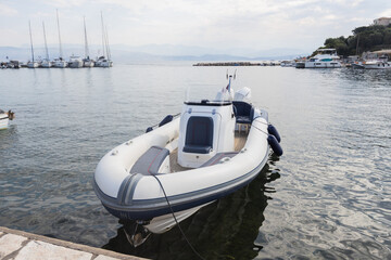 Inflatable rib boat moored at marina dock on calm water