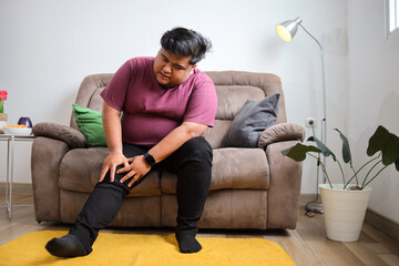 Man Experiencing Knee Pain While Relaxing at Home Seeking Relief and Comfort