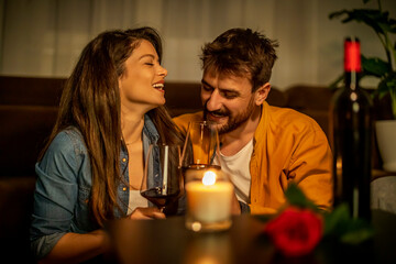 Couple enjoying romantic evening with wine and candlelight at home