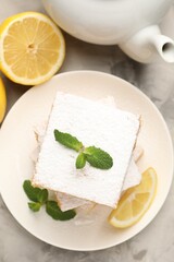 Tasty lemon bars with mint on grey marble table, flat lay