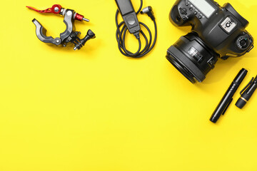 Professional photographer's equipment on yellow background, flat lay. Space for text