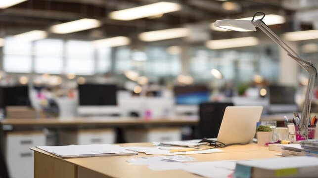 afterhours. A professional desk arrangement in a large office space after work hours, featuring soft overhead lighting. lifestyle magazines.