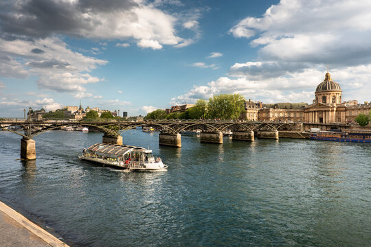 Paris France boat floats under Pont des Arts bridge over Seine River
