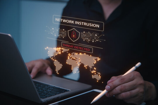 Serious man analyzing network intrusion and data traffic on global map showing system breach and cyber security threat