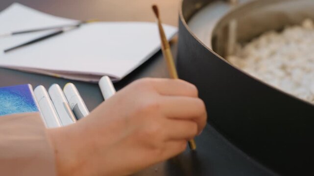 artist preparing materials, calm artist arranging painting tools, female creator organizing watercolor supplies with focus, person calmly setting up art tools in peaceful studio environment