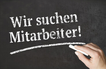 &bdquo;Wir suchen Mitarbeiter!&ldquo; Wort mit Kreide auf einer Tafel