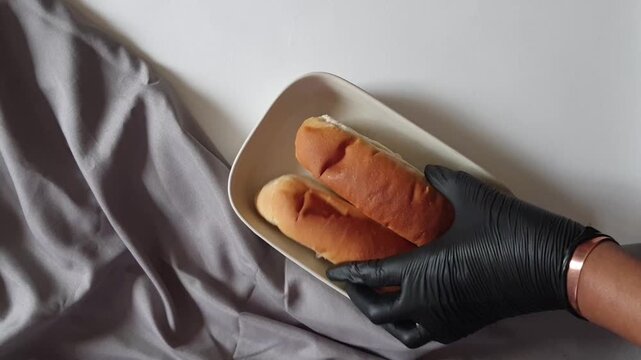 Hotdog Buns Being Set Down on Plate