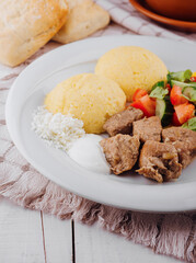 Delicious traditional meal with meat, polenta, and fresh vegetables