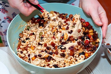 A close-up shot shows a person mixing a bowl of ingredients with a spoon.