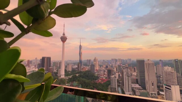 Kuala Lumpur, Malaysia, June 8, 2025: Sunset from an observation deck in Kuala Lumpur. Sunset sky illuminated by twilight, TV tower, and high-rise buildings from the air in the city center. 4K