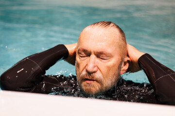 Grey haired free diver swimming in pool 