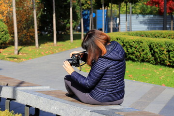 A female photographer, journalist, correspondent takes pictures on the street