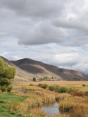 Fototapeta premium Autumn marsh wetlands and rolling hills with sunlight breaking through the clouds