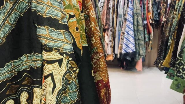 row of traditional indonesian batik fabric and dresses in a clothing store