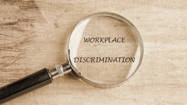 Animation of the conceptual text of WORKPLACE DISCRIMINATION through a magnifying glass, the phrase appears on the papyrus