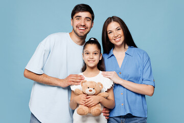 Young smiling cheerful happy parents mom dad with child kid daughter girl wear casual clothes hold...