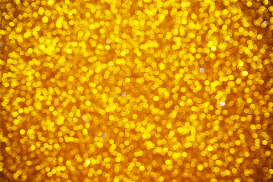 Golden yellow background with shimmering bokeh lights for design. Golden glowing orbs create festive, luxurious, and elegant mood perfect for celebration or holiday themes.