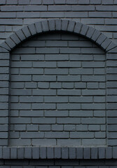 An arched window completely bricked up by a solid layer of bricks
