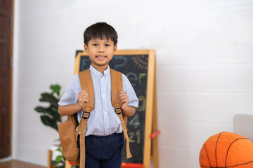 Asian schoolboy wearing uniform with backpack ready to learn at home, representing education, first day of school, childhood learning and academic preparation, education, back to school concept