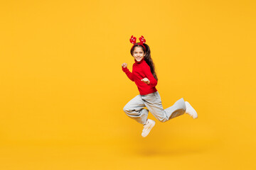 Full body side profile view merry little girl wear red clothes fun decorative deer horns on head...
