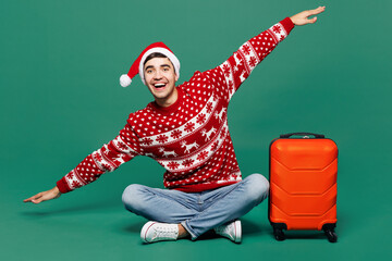 Traveler man wear red clothes hold bag spread hands pov fly isolated on plain green background....