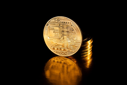 Golden Bitcoin, crypto currency. Bitcoin coin isolated on black background. Stack of gold coins with Bitcoin coin in front of it. Cryptocurrency and electronic decentralized money concept.