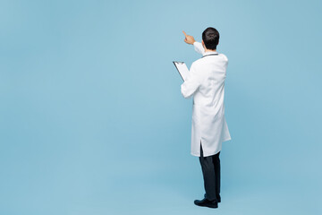Full body young male doctor man wears white medical gown suit work in hospital clinic office hold...