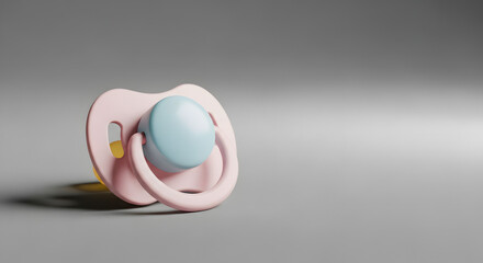 A pastel-colored baby pacifier on a gray background with copy space