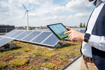 Engineer monitoring solar panels with tablet on rooftop at daytime, renewable energy management and smart technology for sustainable power generation and clean electricity operations
