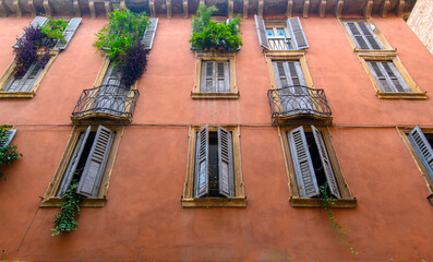 Verona, Italy. Traditional colorful building with balconies, shutter windows and multicolored walls in typical italian street	
