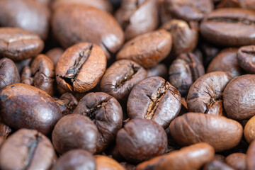 Naklejka premium Rich roasted bean imagery, Close examination of dark roasted coffee beans with shine, Highresolution macro photograph showcasing glossy roasted coffee beans in warm lighting