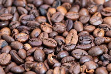 Coffee beans shining, Roasted beans with shimmering oils, Closeup of roasted coffee beans with radiant gloss, Detailed shot of roasted coffee beans reflecting warm studio lighting