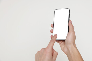 Man holding smartphone with blank screen on white background, closeup. Mockup for design