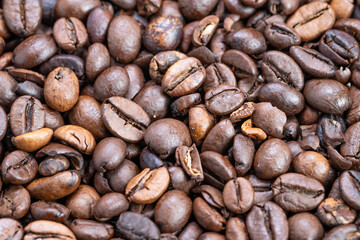Shiny dark roast coffee beans closeup, intense oil gloss and crema hints, deep brown contrast, powerful aroma impression for espresso branding and specialty shop visuals