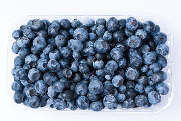 Blueberries in a plastic container isolated on a white background.