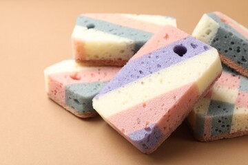 Colorful kitchen sponges on brown background, closeup