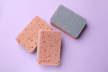 Kitchen sponges on violet background, flat lay