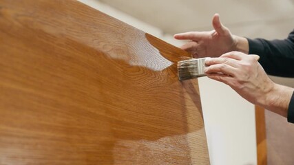 Skilled artisan applying varnish to a wooden surface, showcasing craftsmanship and attention to detail, with a gradual zoom in on the finishing touches